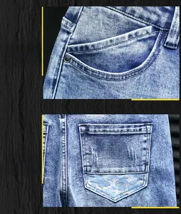 Detail view of denim jeans front pocket with metal rivets and camouflage pattern back pocket
