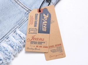 Detailed view of light blue denim with frayed edges and classic paper brand tags