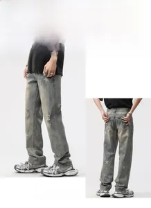 Détail d'un jean bleu délavé pour homme avec imprimés d'étoiles et accents de déchirure