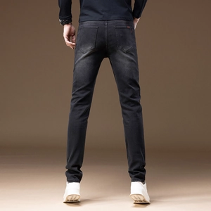 Macro detail of men's slim fit dark grey denim jeans with vintage washed effect and pockets