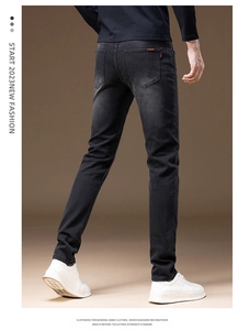 Detailed back view of slim-fit dark grey denim jeans featuring small red label on pocket