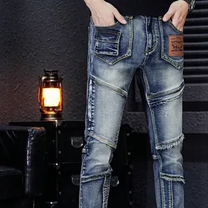 Slim fit men's distressed blue jeans with vintage patchwork and ripped pocket details