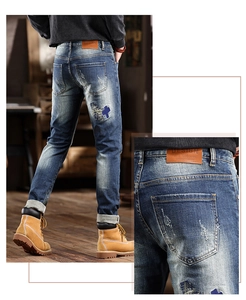 Detail view of American vintage style jeans with leather patch and distressed denim pockets