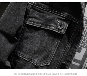 Dettaglio della giacca di jeans nera con bottoni metallici e tasca pettorale con patta