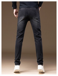 Rear view detail of slim fit charcoal grey denim pants featuring natural washed texture