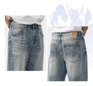 Detailed view of light blue washed denim jeans with metal button and back pocket stitching