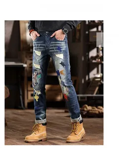 Detailed view of distressed blue denim jeans featuring colorful star and cross patches