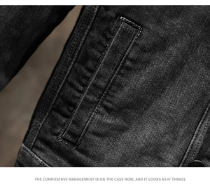 Vista macro delle cuciture rinforzate sulla tasca laterale della giacca denim nera