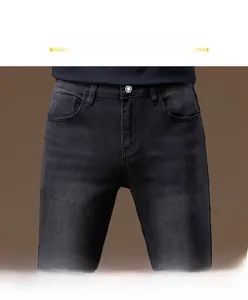 Close-up of black slim fit jeans showing mid-rise waist with metallic button and texture