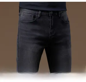 Detailed close-up of side pocket and waist design on dark grey slim fit jeans