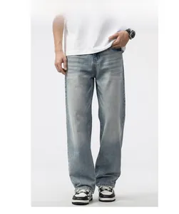 Close-up of men's loose fit grey-blue jeans featuring vintage wash and whisker detailing