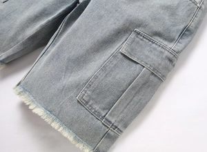 Detail of light blue denim shorts featuring side cargo pockets and frayed raw hem edge