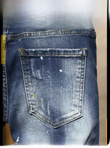 Détail de la poche arrière du jean avec effet délavé et éclaboussures de peinture colorée