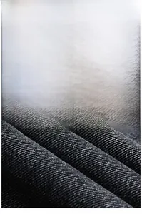 Dettaglio del denim grigio lavato pesante che mostra la trama saia e la qualità del tessuto