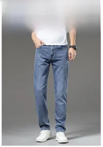 Detailed view of men's slim fit jeans with light blue wash and natural fading texture