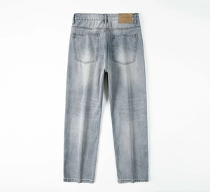 Dettaglio delle tasche posteriori con cuciture a onda e patch in pelle su jeans blu vintage