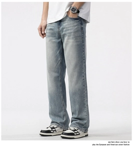 Detailed macro view of light blue washed denim fabric and straight leg cut on men's jeans