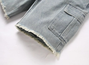 Detailed view of light blue cargo denim shorts featuring tactical pockets and raw frayed hems