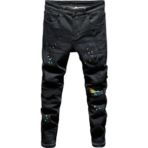 Men's slim fit black jeans with distressed holes and colorful paint splatter details