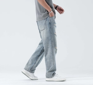 Side view of light blue distressed straight-leg jeans with vintage wash and ripped details
