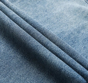 Detailed macro view of light blue heavy washed denim fabric with cotton twill texture
