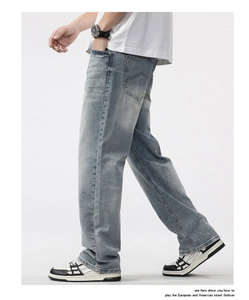 Detail of light blue washed denim jeans showing a loose straight cut and vintage texture