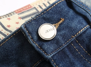 Detail of vintage denim shorts waist with metal button and American flag pattern lining