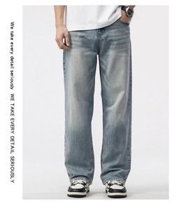 Detail view of light blue washed denim jeans with distressed texture and casual fit