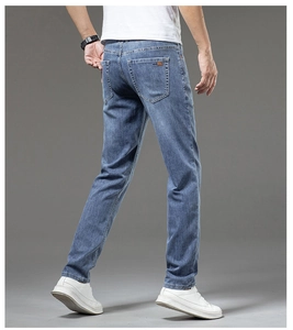 Rear view of men's slim fit jeans in light blue wash showing back pockets and orange label