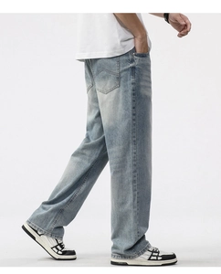 Detailed view of curved stitching on the back pockets of light blue straight denim jeans