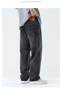 Dettaglio del retro dei jeans larghi grigio scuro lavati con toppa in pelle marrone in vita