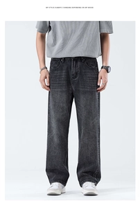 Dettaglio dei jeans grigio scuro lavati da uomo con baffature vintage e scolorimento