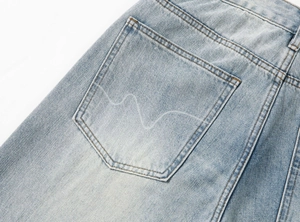 Dettaglio della tasca posteriore su jeans dritti larghi da uomo con lavaggio vintage