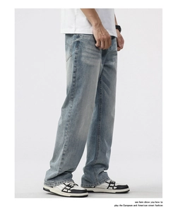 Macro view of light blue washed denim with vintage whisker detail and straight fit