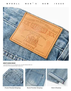 Détail du jean denim délavé bleu clair avec écusson en cuir à la taille et détails aux poignets