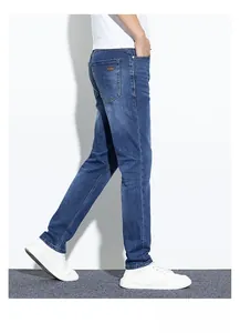 Détail de jean bleu slim avec design classique à cinq poches et étiquette en cuir