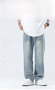 Detail der hellblauen Wide-Leg-Jeans mit einzigartiger schwarz-weißer Farbspritzer-Textur