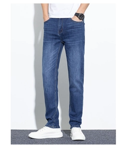 Détail d'un jean bleu ajusté pour homme avec délavage naturel et style urbain vintage