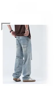 Détail d'un jean coupe droite délavé bleu clair avec finitions déchirées aux genoux