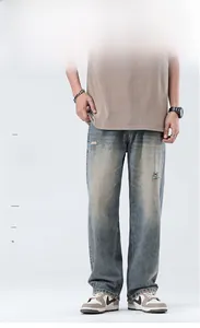 Detailed view of vintage blue distressed jeans featuring distressed holes and whisker texture