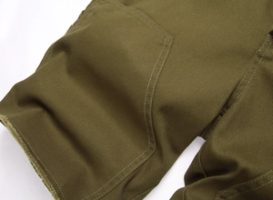 Détail macro du tissu en sergé de coton olive avec poche plaquée et surpiqûres