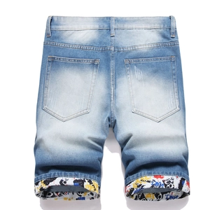 Short en jean bleu délavé pour hommes avec revers à motifs graffiti et détails déchirés