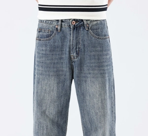 Détail d'un jean bleu délavé avec une texture vintage et des boutons métalliques