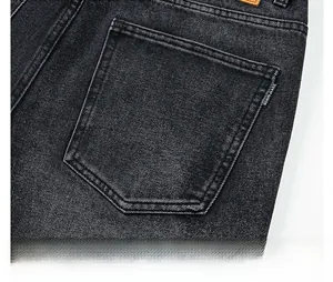 Dettaglio della tasca posteriore in denim con cuciture curate e piccola etichetta jeans