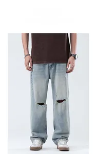 Détail d'un jean large bleu clair avec déchirures aux genoux et bords effilochés