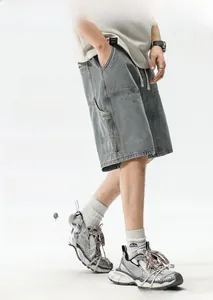 Détail de la poche cargo et de la taille élastique sur le short en jean gris délavé