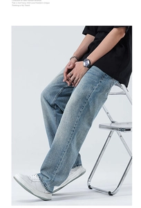 Détail montrant la coupe ample et la texture denim délavé bleu clair du pantalon droit