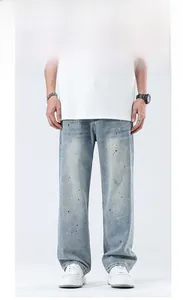 Detail der hellblau gewaschenen Herren Jeans mit bunten Tintenspritzern und lockerem Schnitt