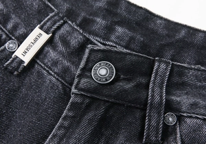 Vue détaillée de la taille du jean en denim gris foncé avec bouton et plaque en métal