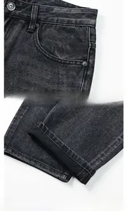 Dettagli di jeans grigio scuro lavati con tasche curve e risvolti cuciti a mano